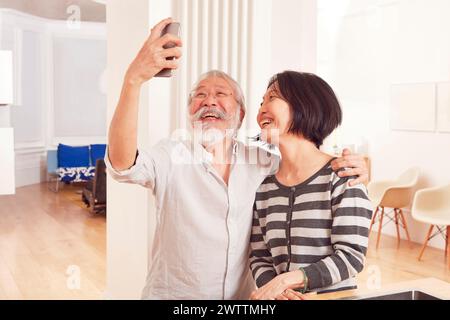 Couple âgé prenant un selfie à l'intérieur Banque D'Images