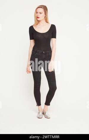 Femme frappant une pose en tenue noire Banque D'Images