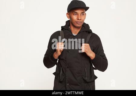 Homme en casquette noire et sweat à capuche posant Banque D'Images