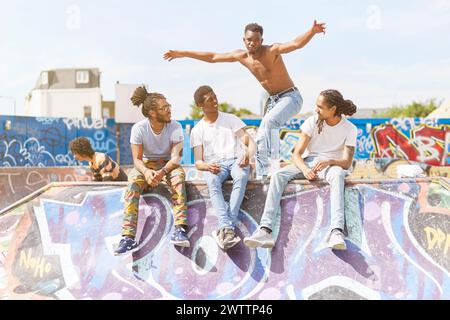 Amis appréciant un skatepark couvert de graffitis Banque D'Images
