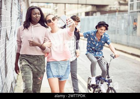 Amis prenant un selfie dans une rue urbaine Banque D'Images