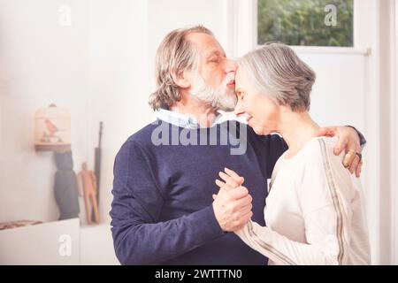 Couple de personnes âgées partageant un moment affectueux. Banque D'Images