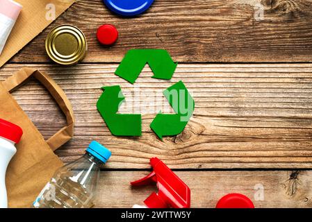 Vue de dessus du symbole de recyclage avec différents matériaux de déchets sur une table en bois avec de l'espace pour le texte. Concept de recyclage respectueux de l'environnement Banque D'Images