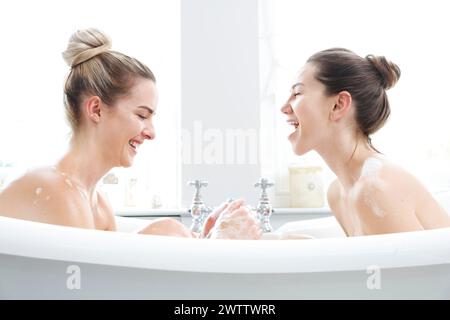 Deux femmes riant dans une baignoire. Banque D'Images