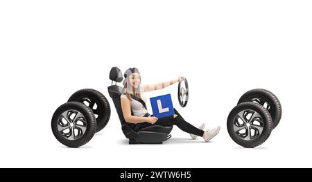 Fille heureuse tenant un signe l dans un siège d'auto isolé sur fond blanc Banque D'Images