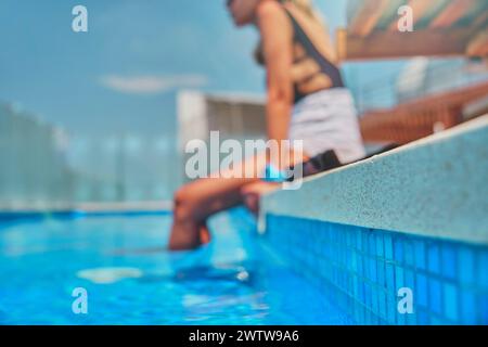 Jambes de femme méconnaissables pendant la journée d'été dans une piscine. Banque D'Images