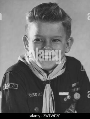 Jeune garçon portant son uniforme de Cub Scouts avec une écharpe, des médailles et des récompenses épinglées sur le devant de sa chemise Banque D'Images