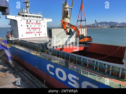 YANTAI, CHINE - 19 MARS 2024 - Une grue charge des excavatrices exportées vers le Brésil dans le cargo «Yantai - Brésil» au port de Yantai, Shandong pr Banque D'Images