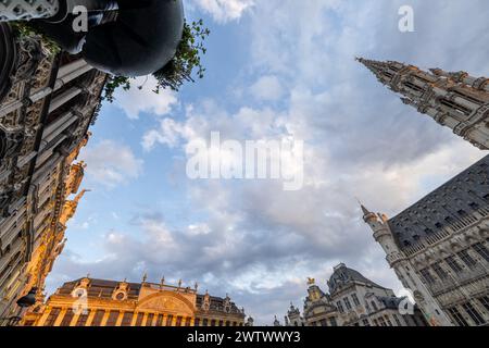 Bruxelles, Belgique, le 23 juin 2023, ce cliché en angle bas offre une vue panoramique sur les façades ornées et les tours imposantes de la Grand-place de Bruxelles, encadrées par un ciel dynamique traversé par une douce lumière du soir. Ciel panoramique au-dessus des tours historiques de la Grand-place à Bruxelles. Photo de haute qualité Banque D'Images