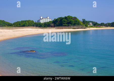 Comté de Goseong, Corée du Sud - 30 juillet 2019 : une vue sur une plage étroite avec des eaux claires de la mer de l'est au premier plan et une promenade cyclin Banque D'Images