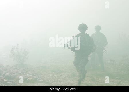 Fort Irwin, Californie, États-Unis. 13 mars 2024. Parachutistes de l'armée américaine, affectés au 2nd Battalion, 508th Parachute Infantry Regiment, 2nd Brigade combat Team, 82nd Airborne Division, se déplacer à travers un terrain désertique vers un objectif au sein d'un village d'opérations militaires sur terrain urbain tirant parti d'un transport d'équipement polyvalent de petite taille de l'armée américaine pendant l'expérimentation d'intégration humaine-machine dans le cadre du projet convergence - Capstone 4, Fort Irwin. (Photo de Griffin Payne) (crédit image : © U.S. Army Navy/ZUMA Press Wire) USAGE ÉDITORIAL SEULEMENT! Non destiné à UN USAGE commercial ! Banque D'Images