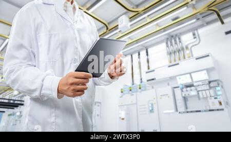 Travailleur ou ingénieur porte le travail de blouse de laboratoire dans l'usine de fabrication de semi-conducteurs Banque D'Images