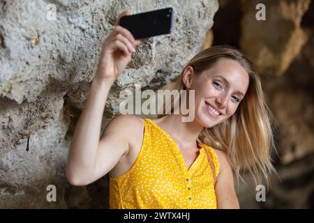 femme touriste prenant des photos sur une grotte Banque D'Images