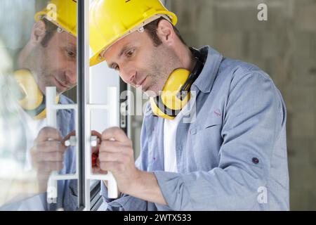 builder visse la poignée sur la fenêtre pvc Banque D'Images