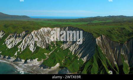 Pistes vertes et vue aérienne sur l'océan bleu. Agrafe. Falaises blanches et rivage bleu contre ciel bleu clair. Banque D'Images