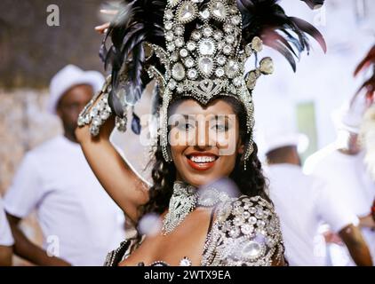 Portrait, femme heureuse et danseuse au carnaval avec bande pour la performance, la fête ou la célébration. Visage, samba et personne brésilienne au festival de musique en Banque D'Images