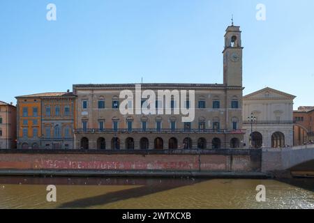 Pise, Italie - mars 31 2019 : le Palazzo Pretorio et sa tour de l'horloge à côté du Logge Dei Banchi et du Ponte Di Mezzo. Banque D'Images