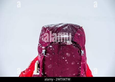 Un routard d'hiver portant un sac à dos Osprey avec un saupoudrage de neige dessus Banque D'Images