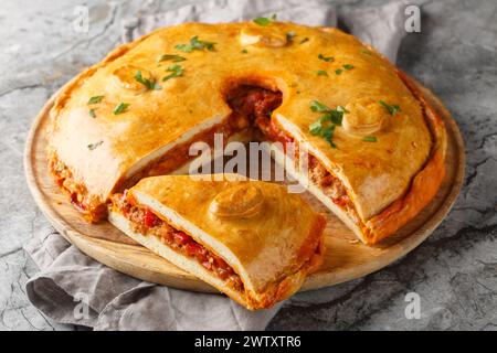 Tarte galicienne ou Empanada Gallega farcie au thon ou à la viande et aux légumes gros plan sur le tableau sur la table. Horizontal Banque D'Images