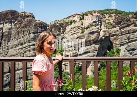 Portrait d'enfants visitant le célèbre monastère des Météores en Grèce. Fille regarde le célèbre monastère des Météores par une journée d'été ensoleillée. Banque D'Images