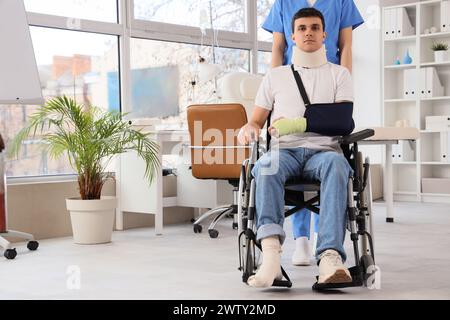 Jeune homme blessé en fauteuil roulant après un accident avec le médecin à l'hôpital Banque D'Images