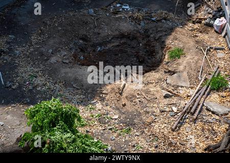 Bangkok, Thaïlande. 17 mars 2024. Gros plan d'un trou après avoir arraché un arbre, avec ses parties laissées sur le côté, après avoir défriché la terre, à la station de MRT Lat Phrao 83, sur Lat Phrao Road, à Bangkok. Le lancement de la ligne jaune MRT (Mass Rapid transit) le 19 juin 2023 a stimulé le développement immobilier le long de la route Lat Phrao de Bangkok, l'une des principales routes de Bangkok. Cependant, des défis persistent en raison des lois sur l'urbanisme limitant les projets de grande hauteur dans la région. (Photo de Nathalie Jamois/SOPA images/SIPA USA) crédit : SIPA USA/Alamy Live News Banque D'Images