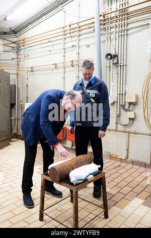 20 mars 2024, basse-Saxe, Munster : Christian Meyer (Alliance 90/The Greens, l), ministre de l'environnement de basse-Saxe, se tient aux côtés d'Ingo Schories (R), responsable de la destruction des munitions et explosifs chez GEKA, lors d’une visite d’un bunker de munitions et d’explosifs appartenant à la Gesellschaft zur Entsorgung chemischer Kampfstoffe und Rüstungs-Altlasten (GEKA), devant une grenade préparée qui a déjà été rendue inoffensive. L'enveloppe de la grenade provient de l'enlèvement des munitions explosives de l'étang de Dethlinger. GEKA soutient l'élimination des gaz toxiques et l'élimination de e. Banque D'Images