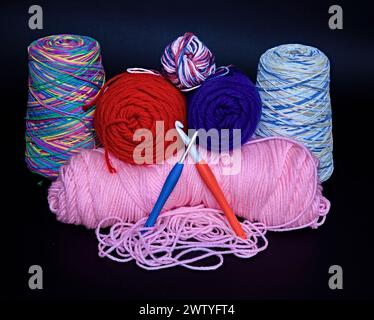 Cônes ou écheveaux colorés brillants de fil au crochet. Avec crochets. Banque D'Images