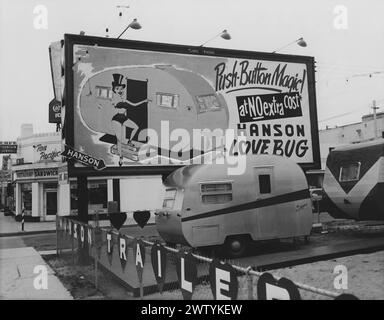 Petite remorque de voyage assis sur un terrain avec d'autres VR à vendre en arrière-plan un panneau d'affichage promeut la magie du bouton-poussoir sans frais supplémentaires, le Hansen Love Bug Banque D'Images