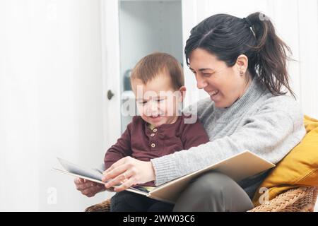 Mère et enfant profitant d'un doux moment de lecture d'une histoire d'enfants, avec de grands sourires sur leurs visages. Copier l'espace. Banque D'Images