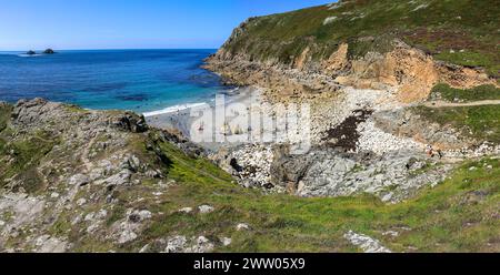 La mer de plage et les rochers de falaise, avec les Brisons au loin, à Cot Valley, Porth Nanven, près de St Just, West Cornwall, Angleterre, Royaume-Uni Banque D'Images