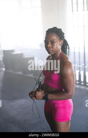 Une femme forte afro-américaine d'âge moyen se tient confiante dans le gymnase Banque D'Images