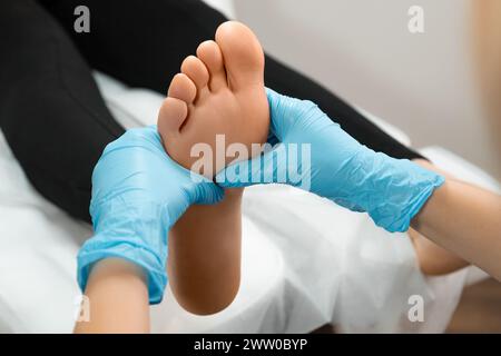 Gros plan des mains du thérapeute ou du podiatre massant le pied féminin Banque D'Images