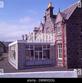 Années 1960, historique, une vue de l'extension arrière de l'hôtel Lochboisdale sur l'île de South Uist, Western Isles, Écosse, Royaume-Uni. L'extension « moderne » de plain-pied est utilisée comme salle à manger. L'hôtel date des années 1880 et la propriétaire du domaine, Lady Gordon Cathcart. Banque D'Images