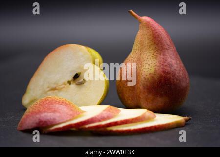 Poires entières et tranches de poire sur ardoise noire Banque D'Images