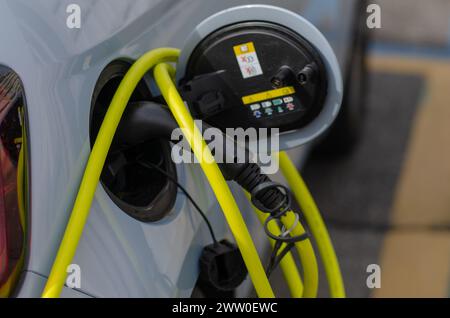 Voiture électrique, ricarica, câble et porte d'alimentation. la transition énergétique accroît les incitations pour les voitures électriques, afin de réduire la consommation d’huile. Banque D'Images