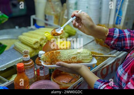 Femme mexicaine préparant un maïs bouilli, cuisine de rue mexicaine typique. Stalle de nourriture. Elote. Banque D'Images