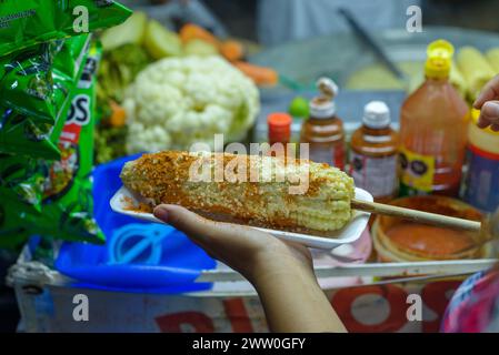 Femme mexicaine préparant un maïs bouilli, cuisine de rue mexicaine typique. Stalle de nourriture. Elote. Banque D'Images