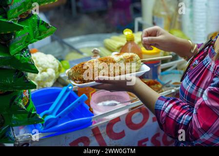 Femme mexicaine préparant un maïs bouilli, cuisine de rue mexicaine typique. Stalle de nourriture. Elote. Banque D'Images