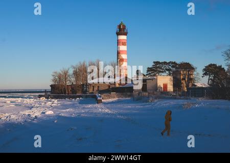 Vue enneigée du phare de Shepelevsky, golfe de Finlande, région oblast de Leningrad, Russie, journée ensoleillée d'hiver avec ciel bleu, phares et balises de Rus Banque D'Images