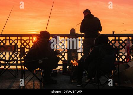 Pêcheurs appréciant le lever du soleil à Istanbul au pont de Galata, Turquie Banque D'Images