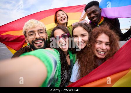 Portrait d'un groupe de personnes prennent un selfie avec un drapeau arc-en-ciel Banque D'Images