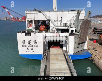 YANTAI, CHINE - 19 MARS 2024 - des camions sont entraînés dans un rouleau de chargement pour l'opération de déchargement à Yantai, province du Shandong, Chine, 19 mars 2024. Banque D'Images