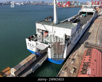 YANTAI, CHINE - 19 MARS 2024 - des camions sont entraînés dans un rouleau de chargement pour l'opération de déchargement à Yantai, province du Shandong, Chine, 19 mars 2024. Banque D'Images