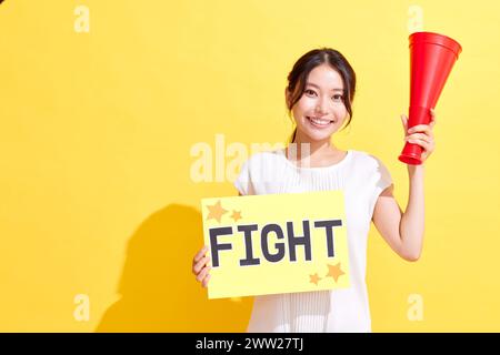 Femme tenant le signe de combat et tenant le mégaphone Banque D'Images