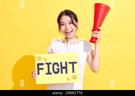 Femme tenant le signe de combat et tenant un mégaphone Banque D'Images