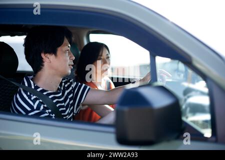 Un homme et une femme assis dans une voiture Banque D'Images