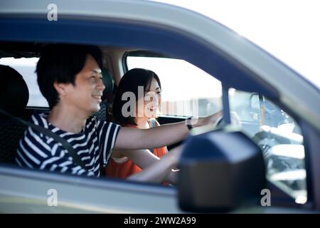 Un homme et une femme conduisant une voiture Banque D'Images