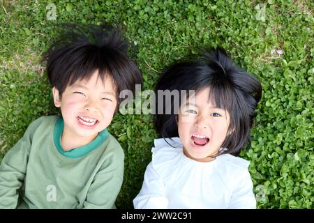 Deux jeunes enfants allongés sur l'herbe Banque D'Images