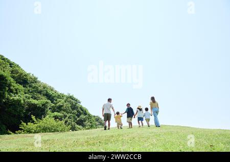 Une famille marchant sur une colline herbeuse Banque D'Images